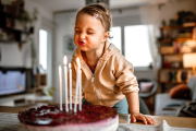 Niña soplando las velas de su tarta de cumpleaños