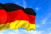 The national flag of Germany with fabric texture waving in the wind on a blue sky. 3D Illustratio