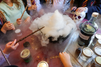 Young witches and wizards casting spells around a cauldron