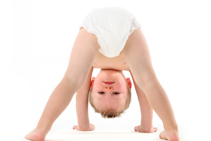 "Little boy playing , looking upsidedown through his legs."