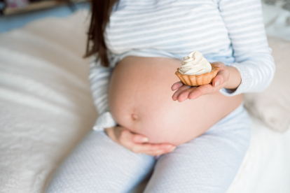 pregnant woman eating delicious sweet cake at home