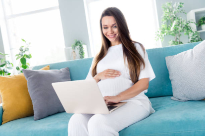 Mujer embarazada utilizando portátil
