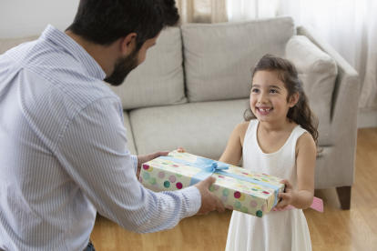 Un hombre entregando un regalo a una niña