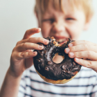 Niño comiendo un donut con perfil poco saludable