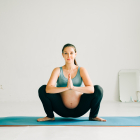 young pregnant girl in sportswear doing yoga, doing asana