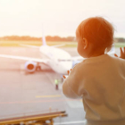 Un bebé en el aeropuerto mirando los aviones tras el cristal.