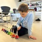 boy playing colored musical bells, music therapy for children with autism