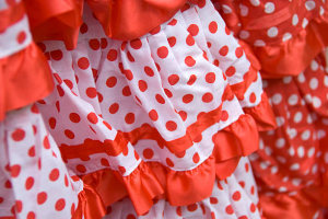 El rojo es un color que nunca pasará de moda en los trajes de flamenca, aunque los lunares conviene que sean de tamaño pequeño para lucir más elegante.