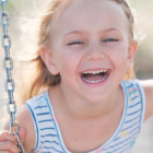 candid portrait of kid laughing while playing at summer park natur